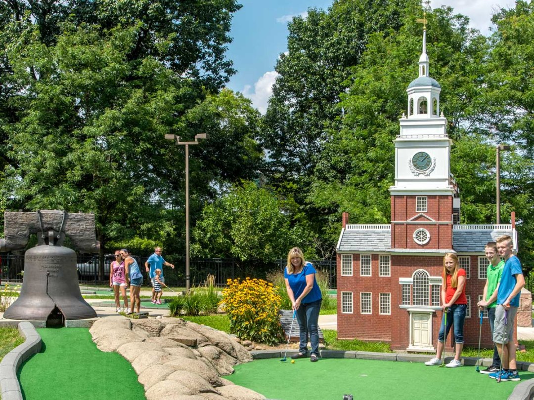 a family plays miniature golf around replicas of Independence Hall and the Liberty Bell