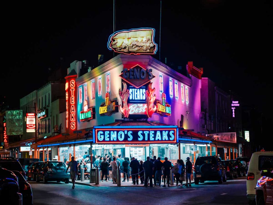 the crowded, brightly-lit outside of Geno's at night