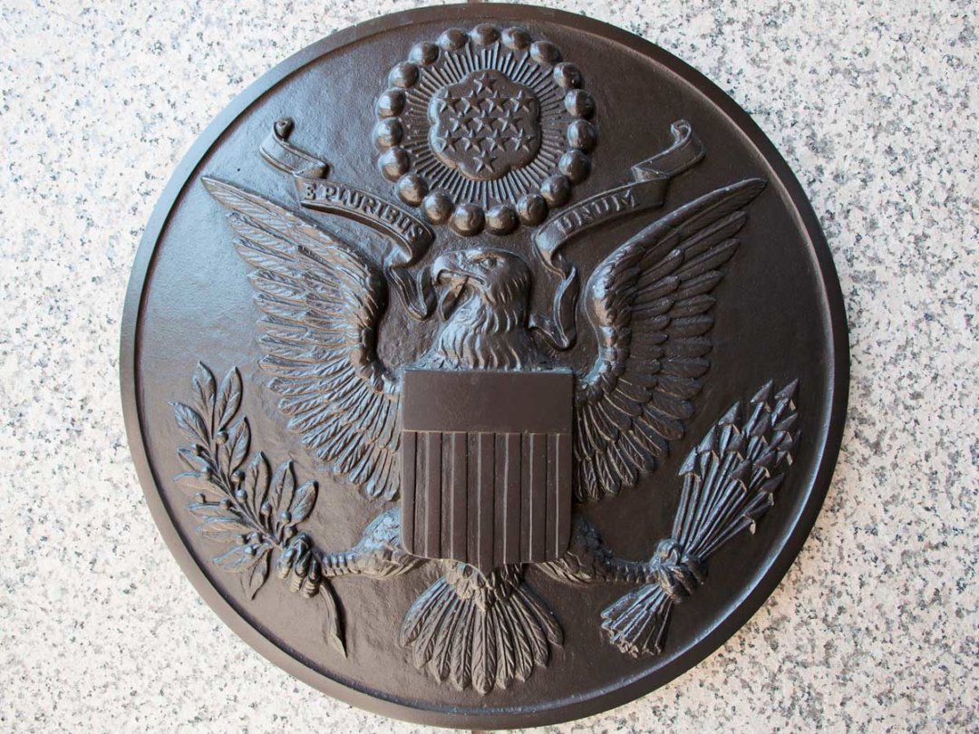 a bronze plate with the United States seal on the mint wall