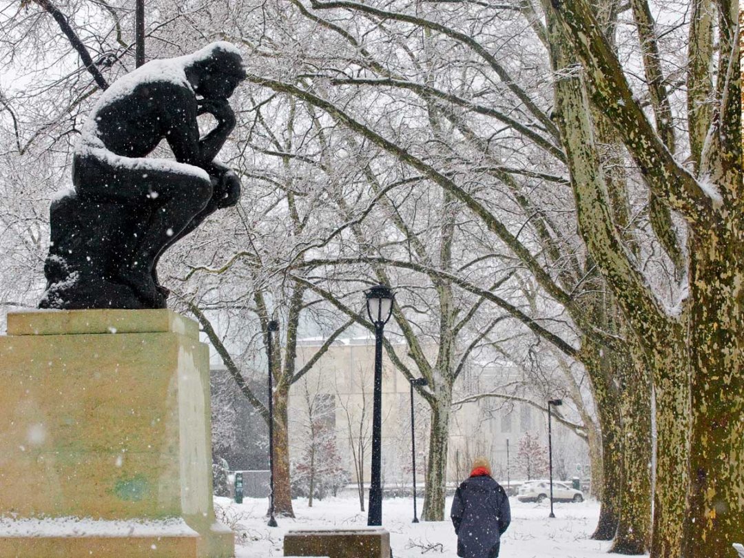 a cast of The Thinker bronze sculpture dusted with snow outside the museum