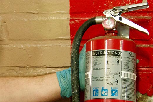 a gloved hand holds a fire extinguisher