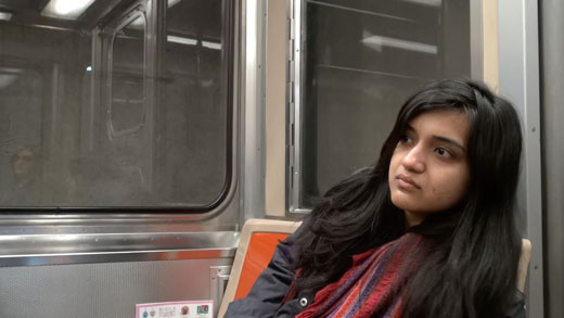 a young woman sits and listens on the Broad Street line